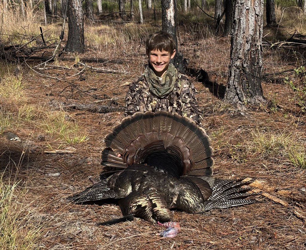 kid holding gobbler turkey